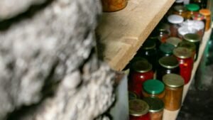Jars of preserved food on shelves in a cellar