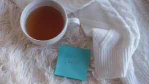 A warm cup of tea next to a cosy sweater
